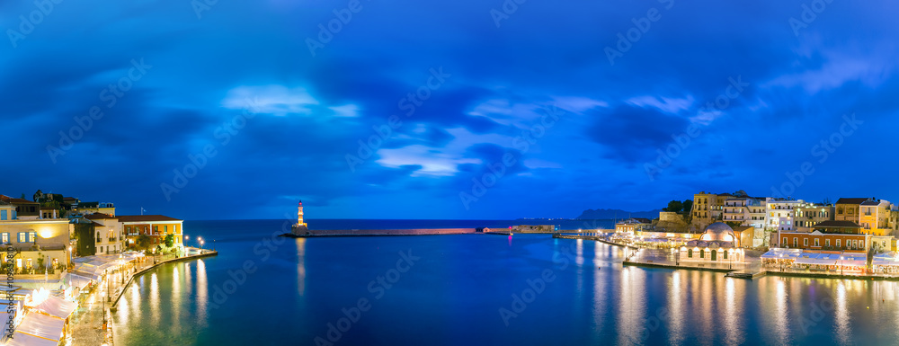 Picturesque panoramic view of old harbour of Chania with Lighthouse and Kucuk Hasan Pasha Mosque during twilight blue hour, Crete, Greece
