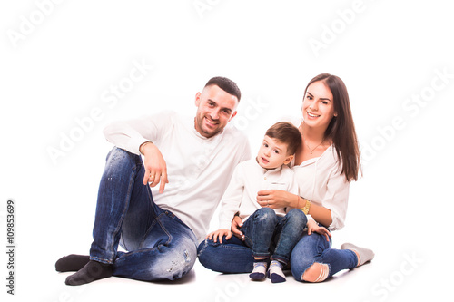 Happy young family with pretty child posing on white background