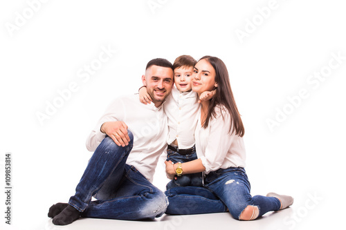 happy family mother and father with son sitting on the floor on white