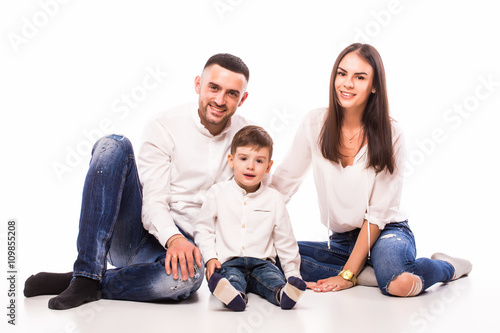 happy family mother, father and son sitting on the floor on white