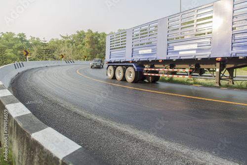 Selrctive focus of road curve and blurled truck driving on a mou