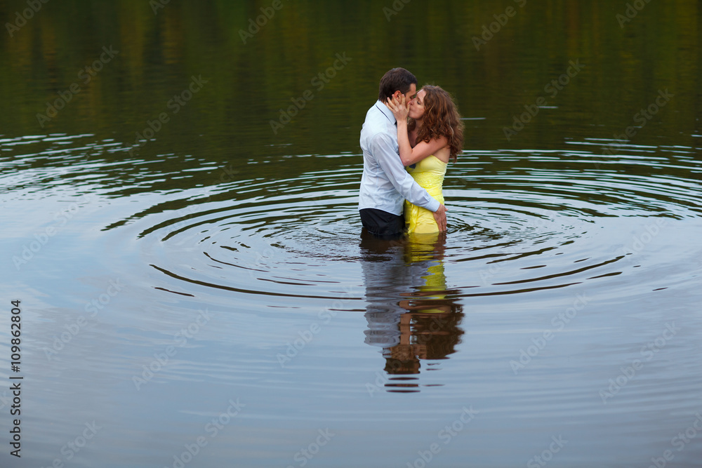 Fototapeta premium Man kisses a woman standing in water