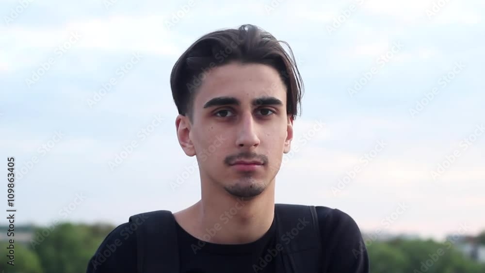 Handsome Guy Looking at the Camera and Smiling. Hipster Very Stylish and Welcoming. His Face Has a Mustache and Beard.