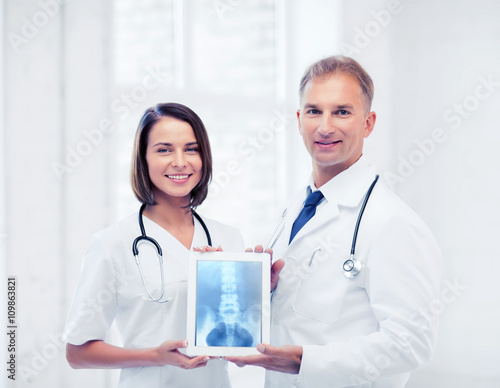 two doctors showing x-ray on tablet pc