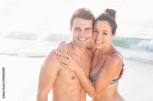 Portrait of happy couple embracing on the beach