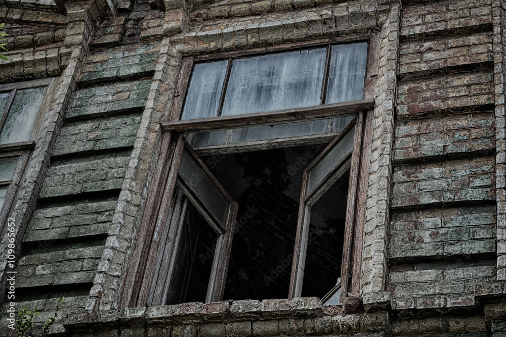 Окна старого жутковатого заброшенного страшного дома. Здесь совершенно убийство и живет призрак 