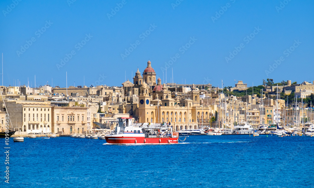 Passenger boat crosses Grand Bay, Valetta, Malta, on a bright sunny morning