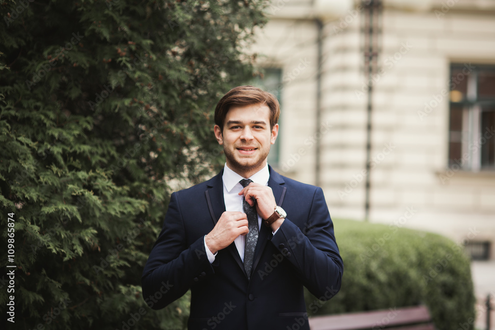 Young stylish businessman adjusting his suit, neck tie Young stylish businessman adjusting his suit, neck tie