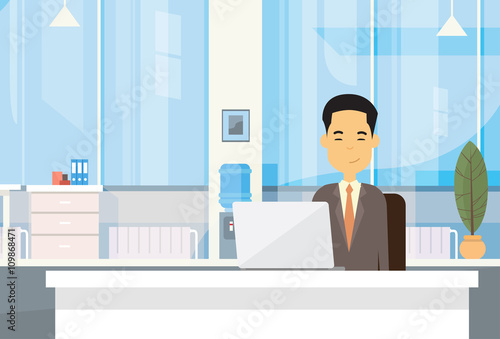 Asian Business Man Sitting At Desk In Office Working Laptop Computer