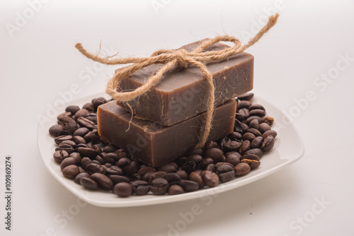 Traditional home made natural coffee soap with a pile of coffee beans on the background suggesting healthy organic non toxic wash products photo