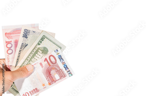 Ten euro banknote on hand with other currencies