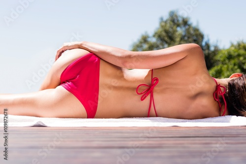 Fotografia Woman enjoying sunbath on the pool edge