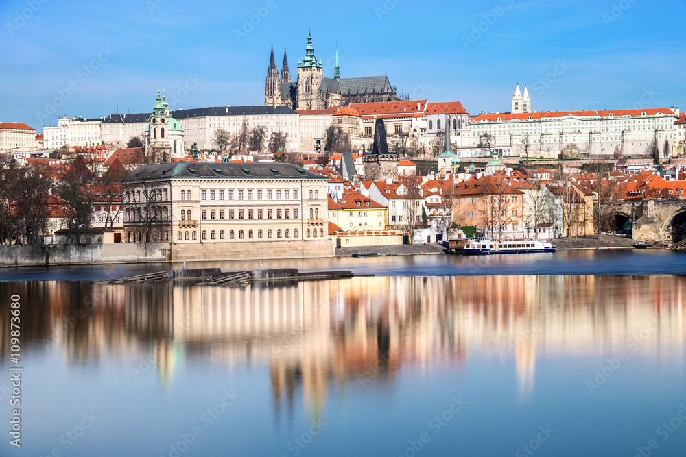 Obraz premium Charles Bridge, St. Vitus Cathedral and other historical buildings in Prague reflected in the river