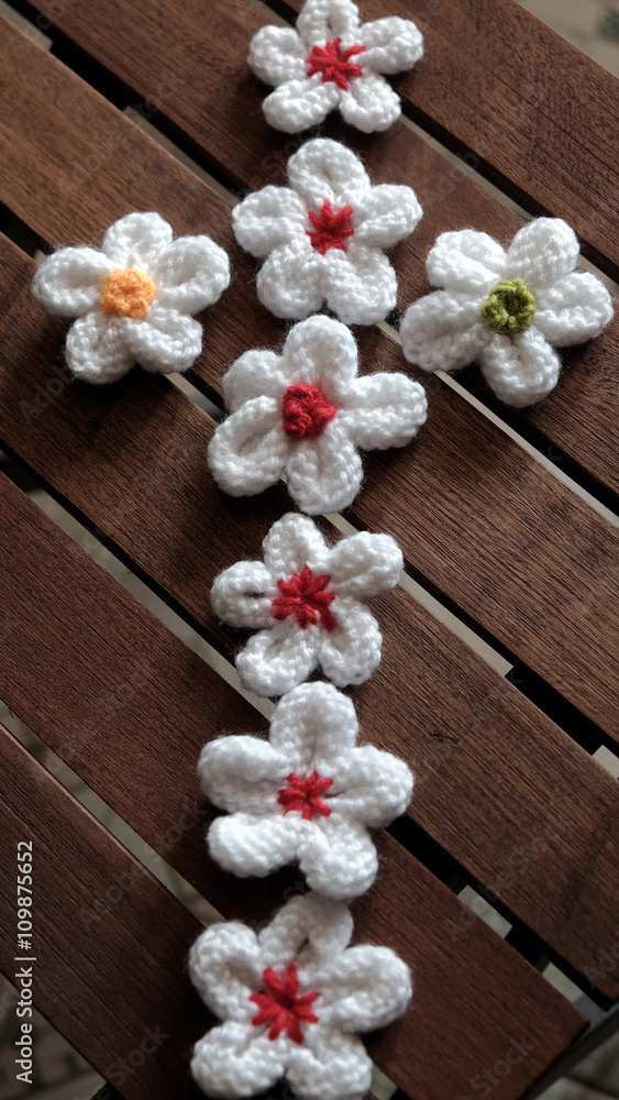 knit daisy flower on wood background knit daisy flower on wood background