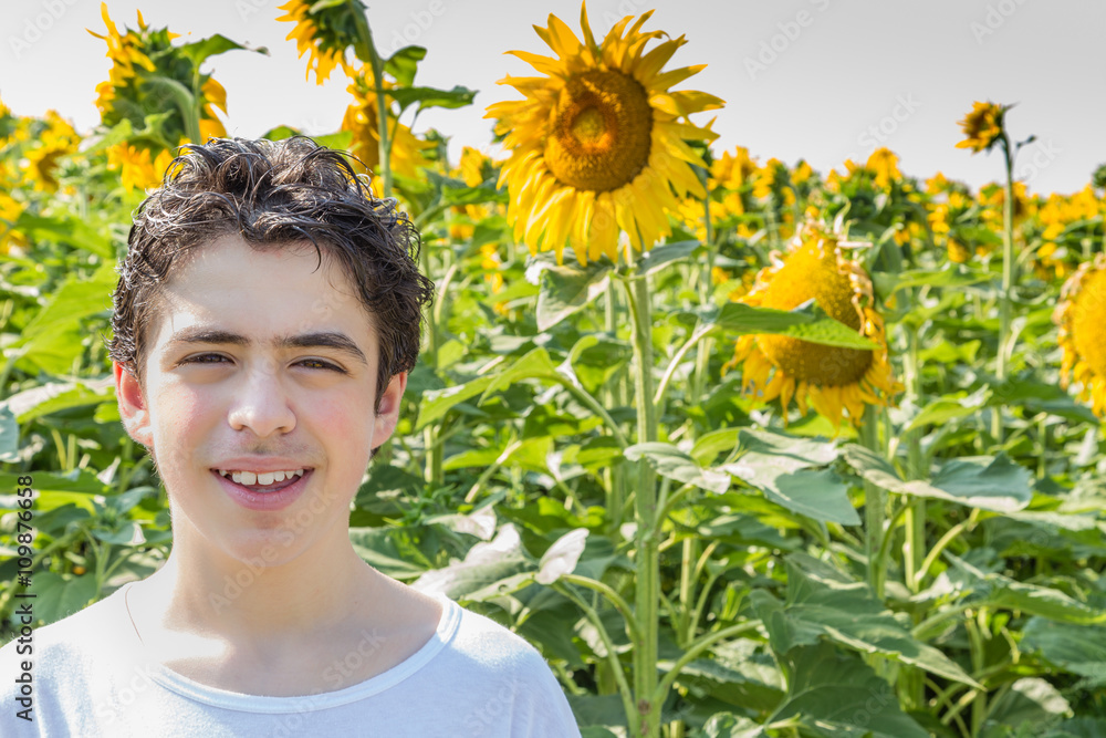 boy smiling in front of sunflower field boy smiling in front of sunflower field