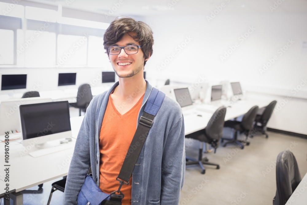 Portrait of happy student standing in computer class