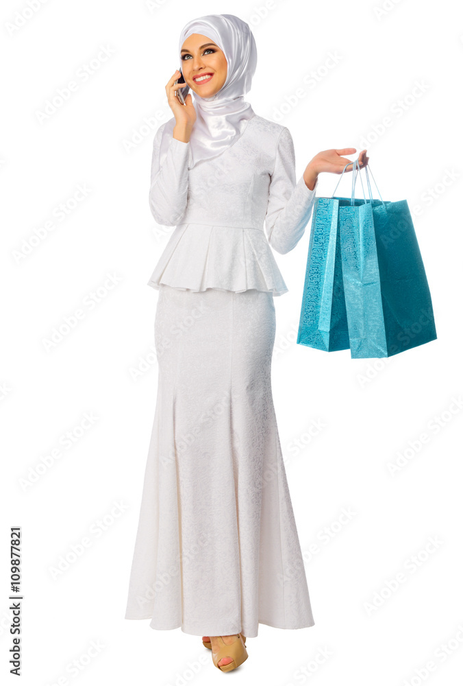 Portrait of young muslim woman with mobile phone and bags Portrait of young muslim woman with mobile phone and bags