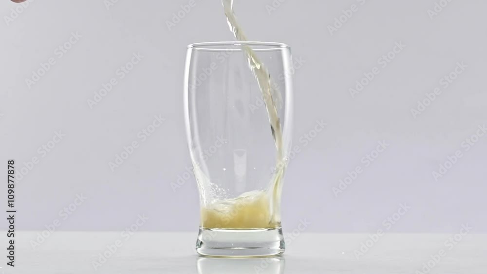 Beer is pouring into glass on white background. Slow motion Beer is pouring into glass on white background. Slow motion