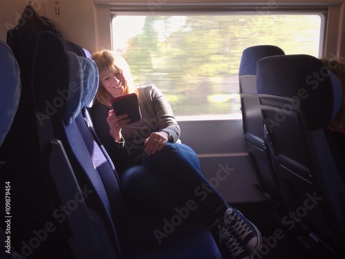 Frau liest Buch im Ebook Reader während Zugfahrt © TeamDF