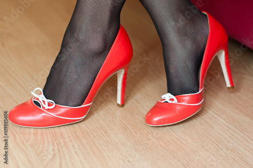 détail pieds de femme avec chaussures rouge à talons haut et bas noirs