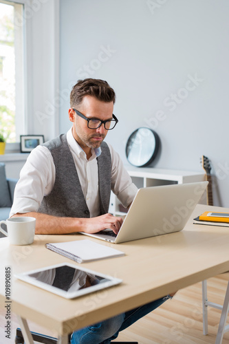 Designer working on laptop from home.