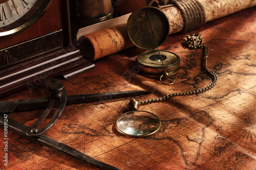 Old vintage retro compass on ancient world map. Vintage still li