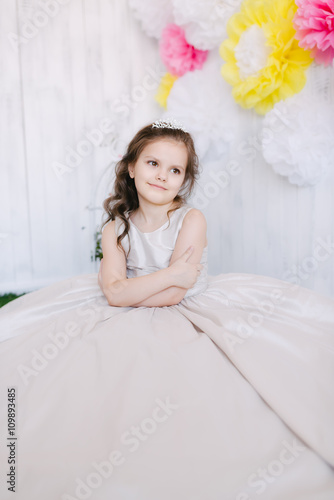 girl in studio sits on a flower background