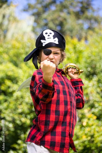 A kid with a costume of pirate is showing his strength