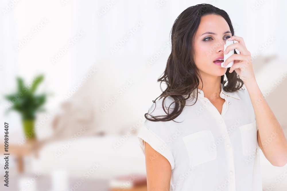 Composite image of asthmatic brunette using her inhaler Composite image of asthmatic brunette using her inhaler
