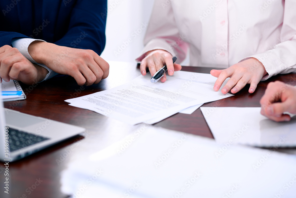 Group of business people and lawyers discussing contract papers sitting at the table, close up Group of business people and lawyers discussing contract papers sitting at the table, close up