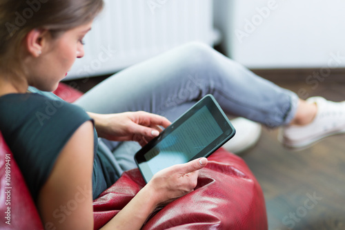 Woman reading an ebook at her home