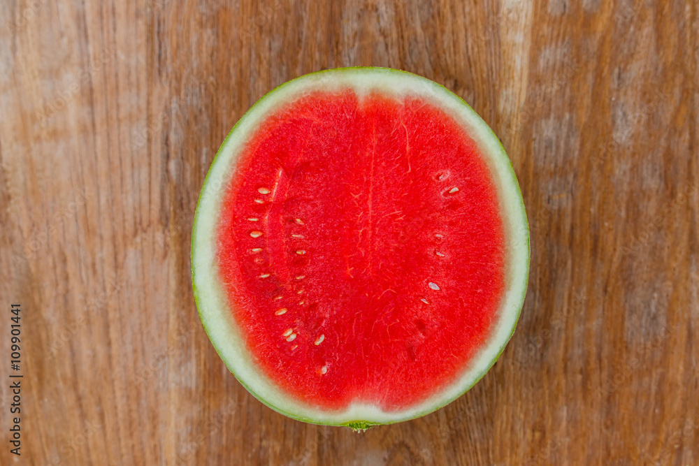 Cut in half watermelon on old wooden table Cut in half watermelon on old wooden table