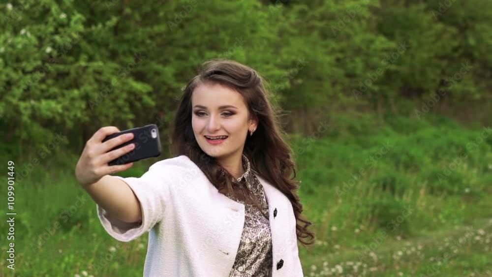 Pretty young girl posing for selfie in the garden. Slowly Pretty young girl posing for selfie in the garden. Slowly