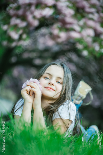 Little girl on grass in bloom