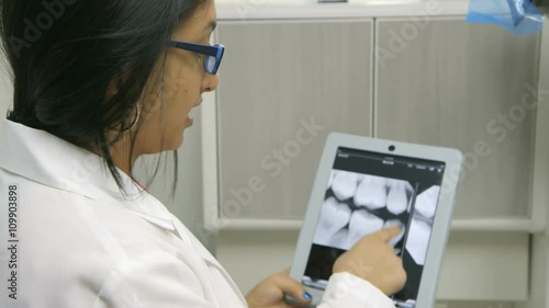 Wallpaper Mural A female dentist or intern reviewing a dental x-ray explains what she sees to a patient who is off camera. Torontodigital.ca