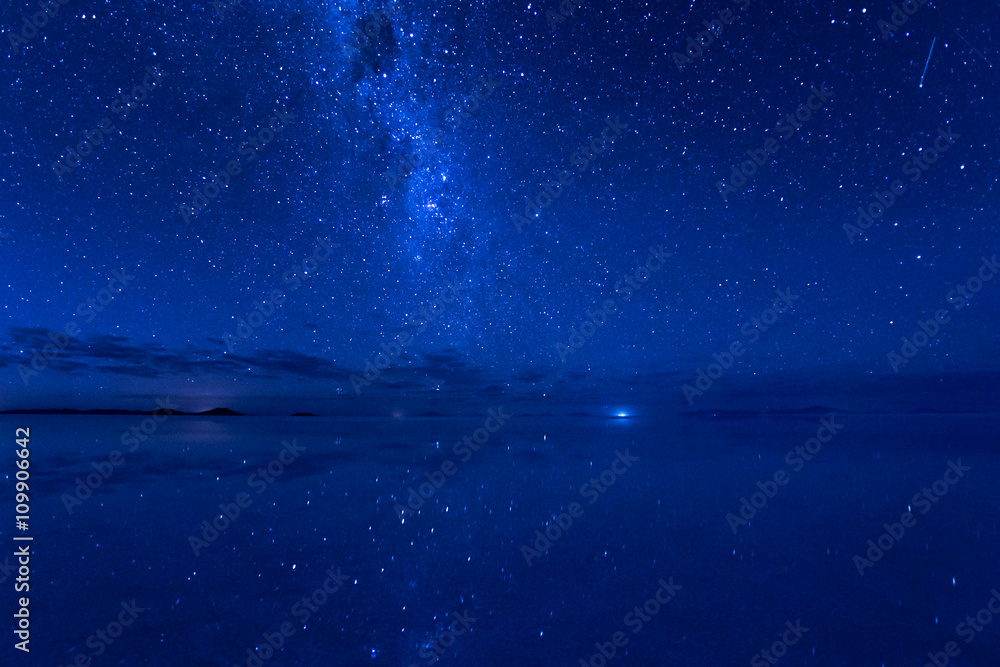 Naklejka Uyuni, Droga Mleczna i spadające gwiazdy w wodzie. Galaktyka Mlecznej Drogi i spadająca gwiazda odbijają powierzchnię wody.