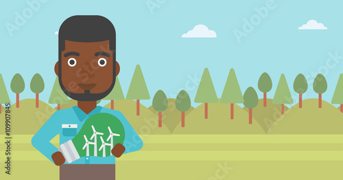 Man holding lightbulb with windmills inside.