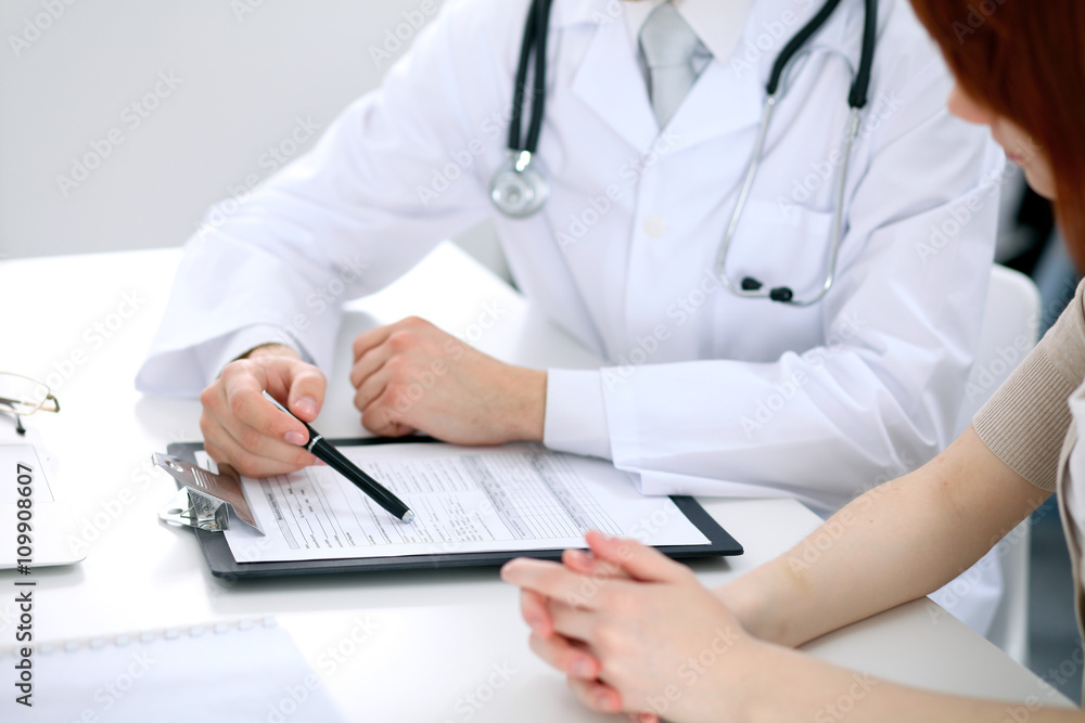 Doctor and patient are discussing something, just hands at the table Doctor and patient are discussing something, just hands at the table