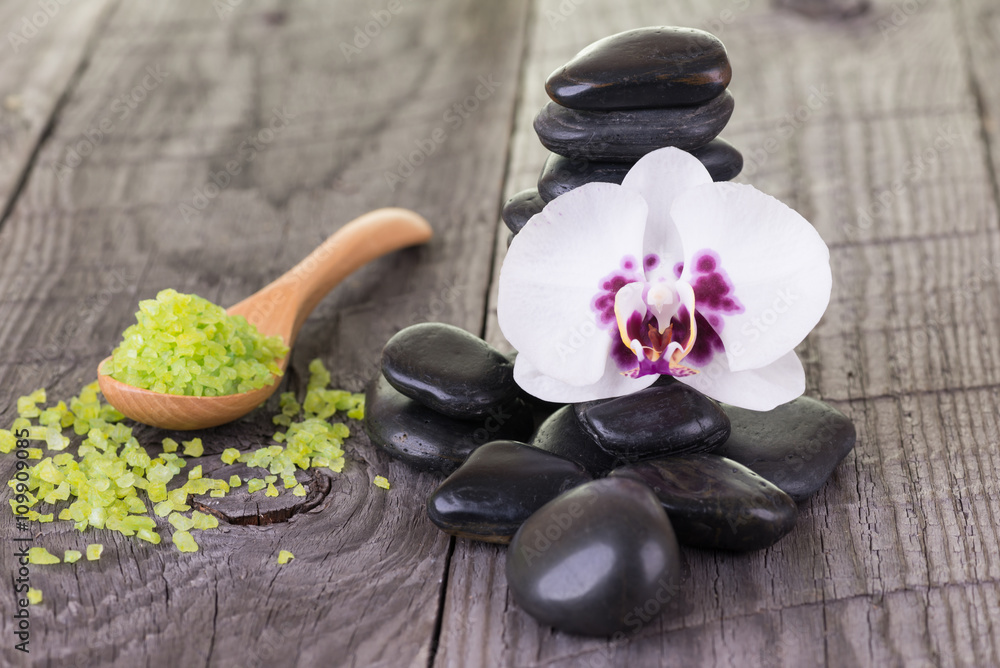 Phalaenopsis orchid, bath salt and black stones on wooden background Phalaenopsis orchid, bath salt and black stones on wooden background