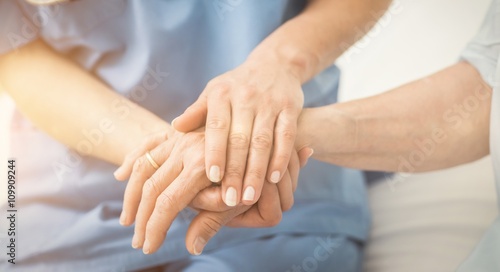 Composite image of nurse holding patient hand