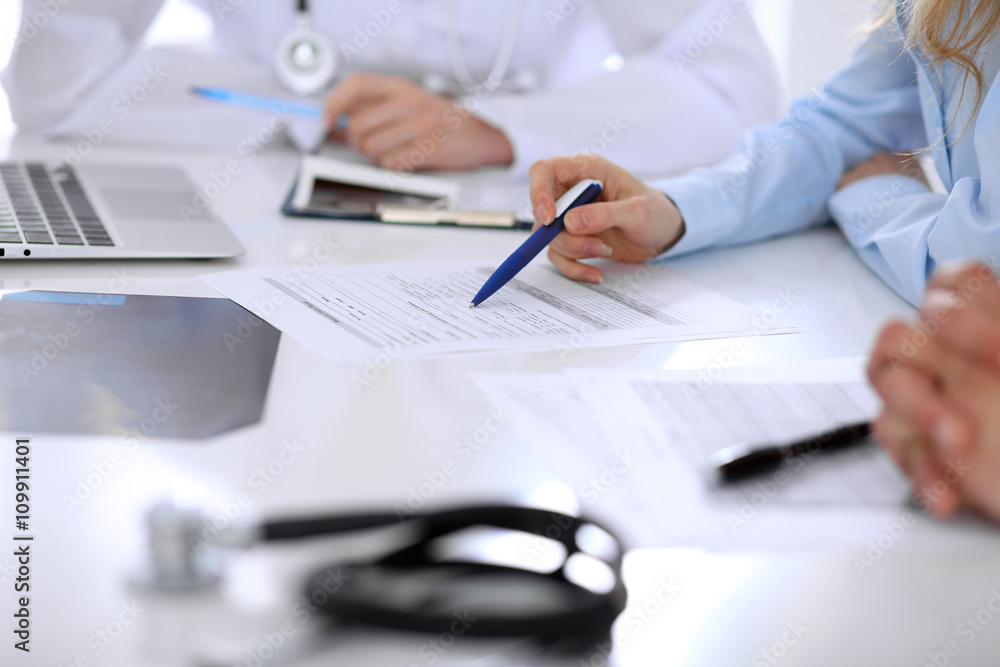 Medical doctor and young couple patients discussing something at the table . Hands close-up Medical doctor and young couple patients discussing something at the table . Hands close-up