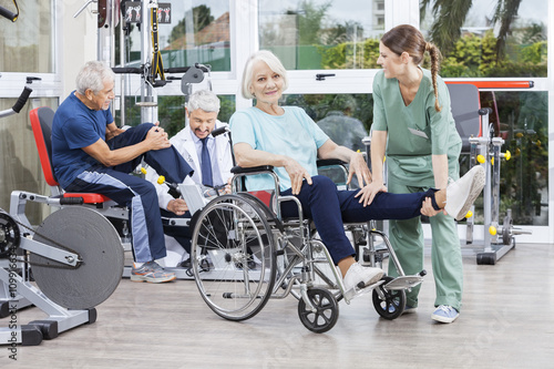 Physiotherapists Guiding Senior Patients To Exercise At Rehab Ce