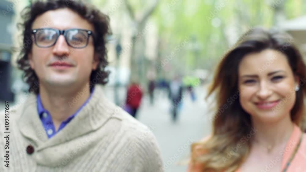 Couple holding hands while walking and smiling to the camera, steadycam shot
Couple holding hands while walking and smiling to the camera, steadycam shot