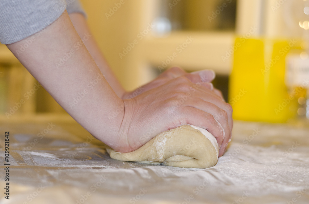 Female hands in flour closeup kneading dough