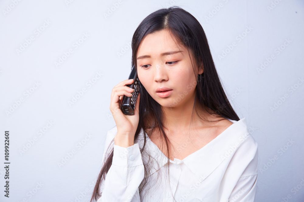 sad Chinese woman talking on a phone sad Chinese woman talking on a phone