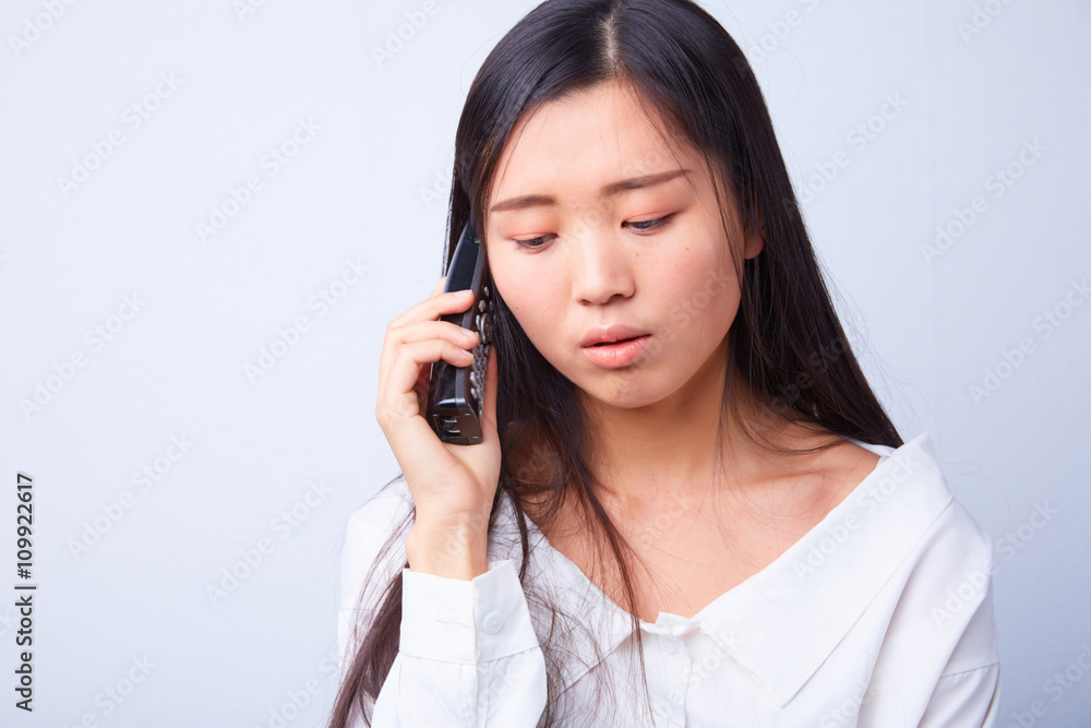 sad Chinese woman talking on a phone sad Chinese woman talking on a phone