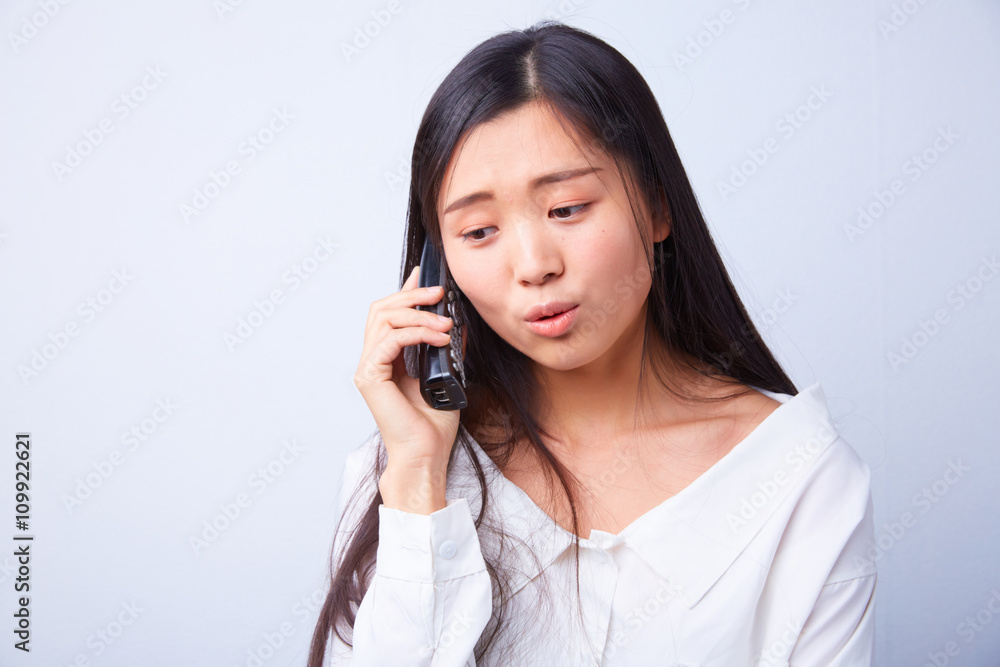 sad Chinese woman talking on a phone sad Chinese woman talking on a phone