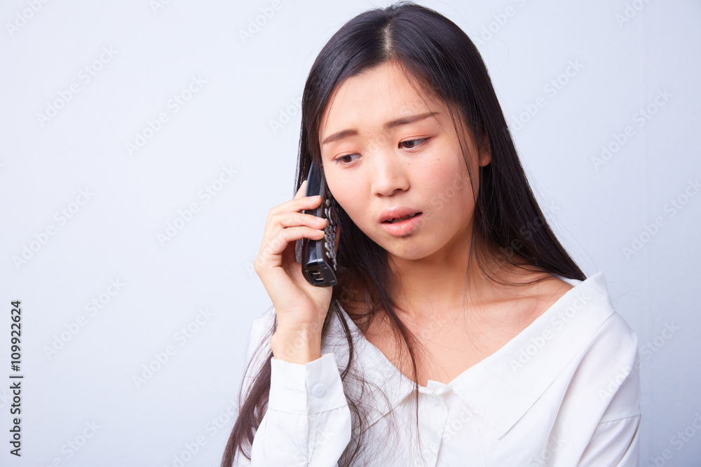 sad Chinese woman talking on a phone sad Chinese woman talking on a phone
