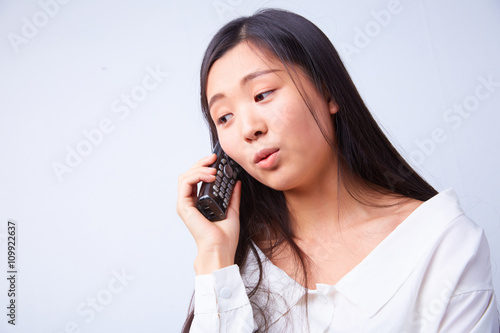 sad Chinese woman talking on a phone