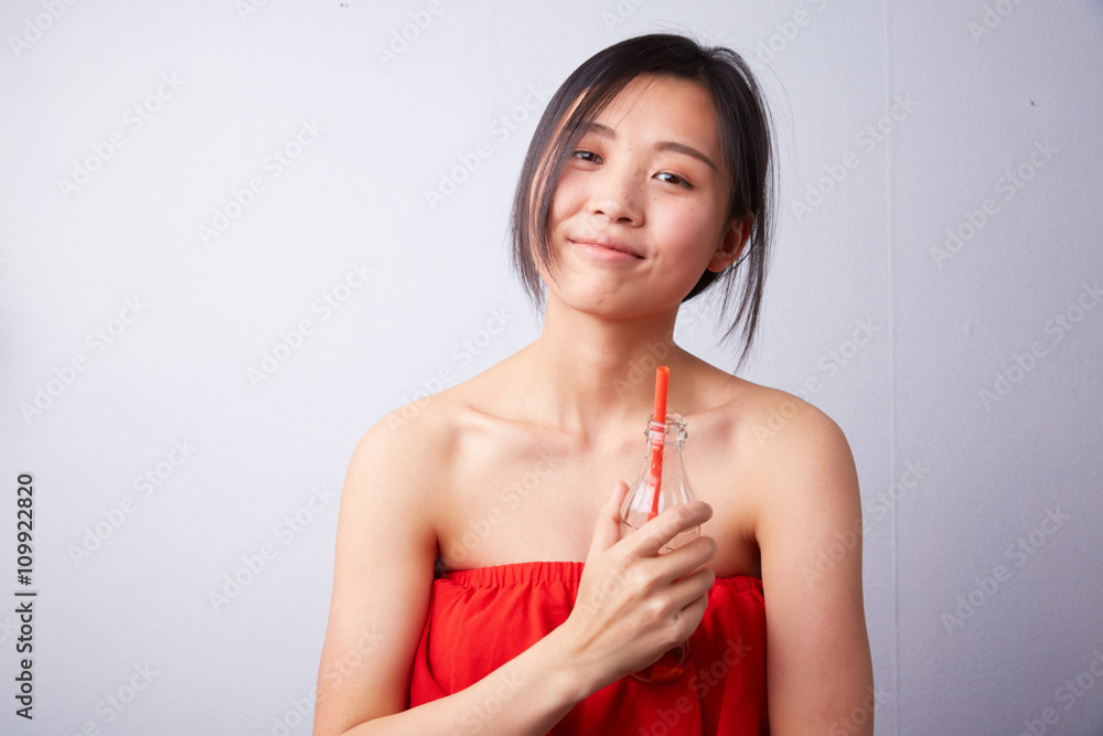 Chinese woman drinking carbonated drink through a straw Chinese woman drinking carbonated drink through a straw